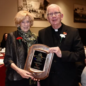 Elizabeth Neumuier Esq. receiving here CGA award with Father Marc Fallon